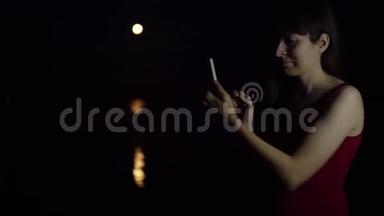 一个年轻的女人在河边拍红月亮。